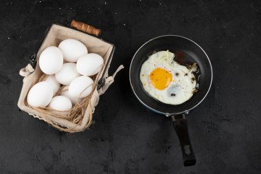 Kızartma tavasında ve yumurta sepetinde kızarmış yumurtalarla nefis bir kahvaltı. Yüksek kalite fotoğraf
