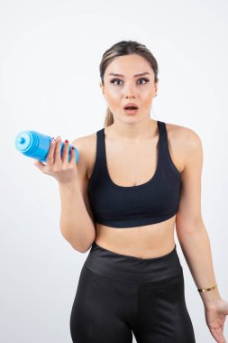 Mavi su şişesi tutan genç atletik kadın portresi. Yüksek kalite fotoğraf