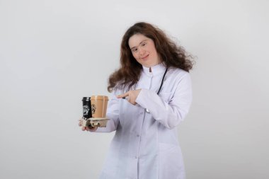 Beyaz üniformalı genç bir kız modelin elinde kahve bardaklarıyla bir karton resmi. Yüksek kalite fotoğraf
