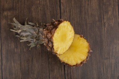 Tahta arka planda tacı olan iki parça ananas. Yüksek kalite fotoğraf