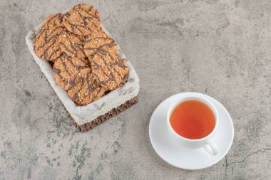 Sepette çikolata jöleli leziz çoklu tahıllı kurabiyeler ve bir fincan çay. Yüksek kalite fotoğraf