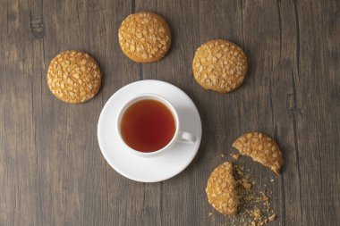 Tohumlu lezzetli yulaf ezmeli bisküviler ve ahşap masada bir fincan sıcak çay. Yüksek kalite fotoğraf