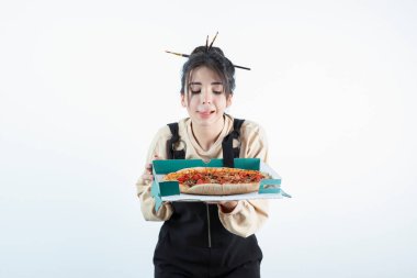 Lezzetli pizzayla dolu bir kutu tutan genç bir kadın. Yüksek kalite fotoğraf