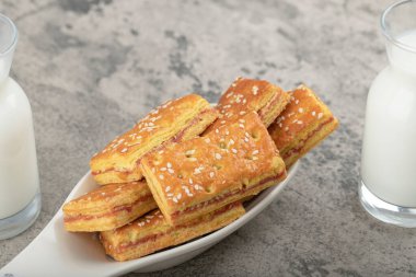 Susam tohumlu krakerler ve cam sürahiler bir taş masaya konmuş. Yüksek kalite fotoğraf