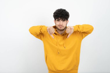 Sarı kapüşonlu, poz veren esmer bir adamın fotoğrafı. 