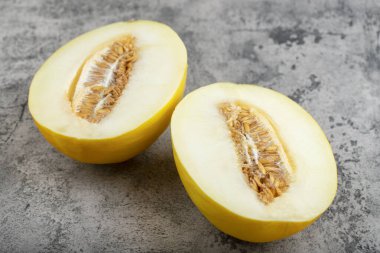 Taş zemine yarım dilimlenmiş sarı kavun yerleştirilmiş. Yüksek kalite fotoğraf