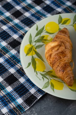 Güzel bir tabağa yerleştirilmiş lezzetli tereyağlı kruvasanlar. Yüksek kalite fotoğraf