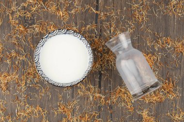 Bir kase taze soğuk süt ve boş cam sürahi ahşap masanın üzerine. Yüksek kalite fotoğraf