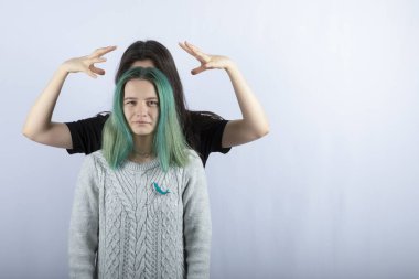 Genç bir kadın beyaz arka planda arkadaşıyla oynuyor. Yüksek kalite fotoğraf