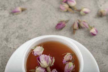 Taş yüzeyinde kurumuş güller olan bir fincan siyah çay. Yüksek kalite fotoğraf