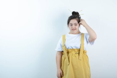 Beyaz duvara karşı duran ve poz veren genç, güzel bir kız. Yüksek kalite fotoğraf