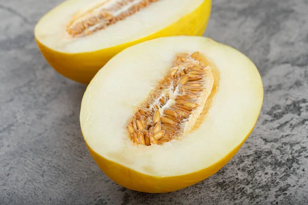 Taş zemine yarım dilimlenmiş sarı kavun yerleştirilmiş. Yüksek kalite fotoğraf