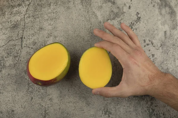 Mannelijke Hand Met Een Stuk Mango Een Marmeren Oppervlak Hoge — Stockfoto