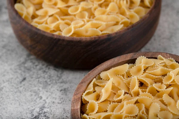 Eine Hölzerne Schüssel Rohe Pasta Auf Steingrund Hochwertiges Foto — Stockfoto