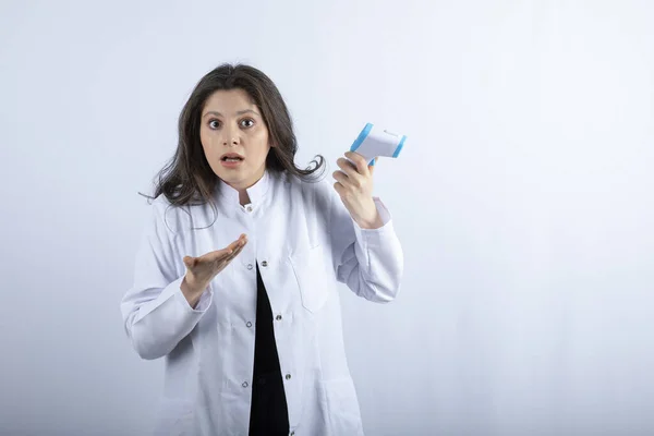 Foto Jovem Médico Segurando Termômetro Fundo Branco Foto Alta Qualidade — Fotografia de Stock