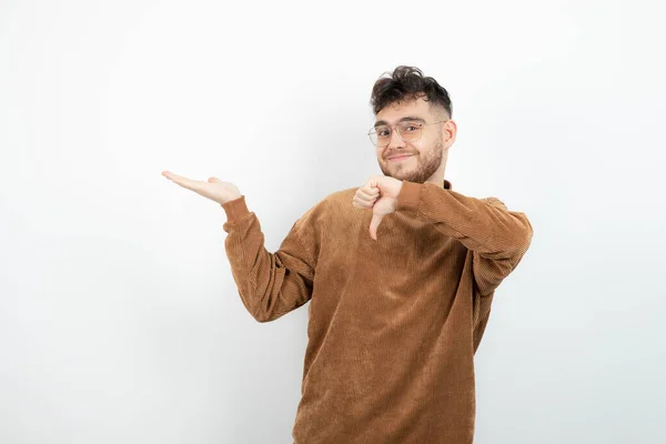 Foto Joven Guapo Sosteniendo Espacio Abierto Dando Pulgares Hacia Abajo — Foto de Stock