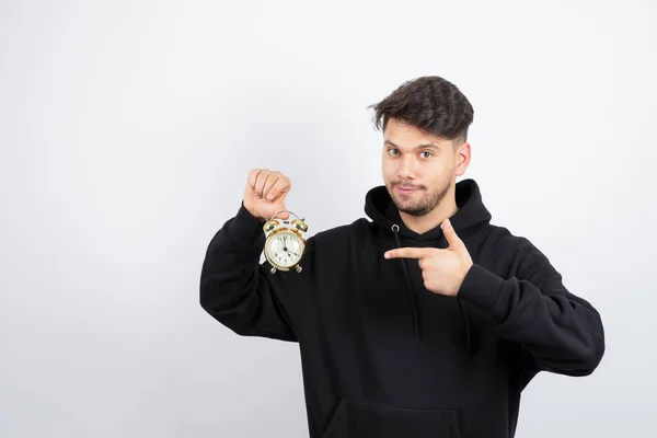 Hombre Guapo Apuntando Reloj Despertador Vintage Sobre Una Pared Blanca —  Fotos de Stock