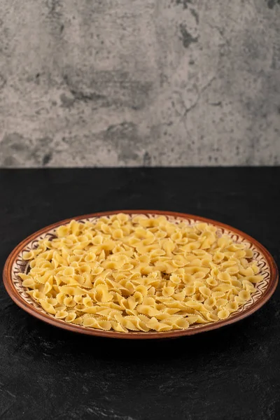 Brown Plate Raw Macaroni Placed Black Background High Quality Photo — Stock Photo, Image