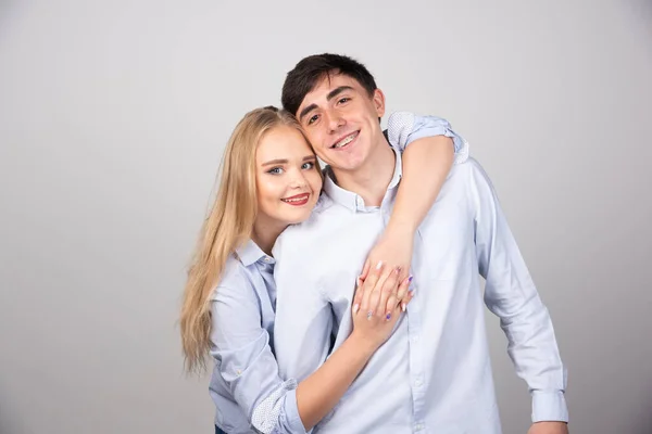 Retrato Una Joven Pareja Abrazándose Sobre Una Pared Gris Foto —  Fotos de Stock