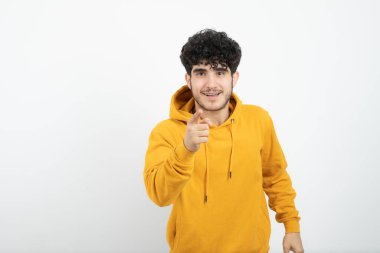 Sarı kapüşonlu, poz veren esmer bir adamın fotoğrafı. 