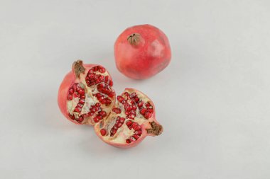 Beyaz masada dilimlenmiş taze nar ve komple nar. Yüksek kalite fotoğraf