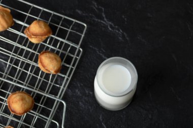 Siyah arka planda cevizli kurabiye olan süt şişesinin üst görüntüsü. Yüksek kalite fotoğraf