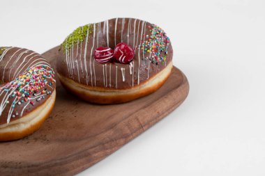 Tahta kesme tahtasına yerleştirilmiş iki lezzetli çikolatalı çörek. Yüksek kalite fotoğraf