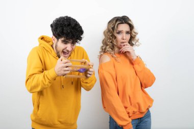 Sarı kazaklı genç adam kız arkadaşıyla kum saatini kontrol ediyor. Yüksek kalite fotoğraf