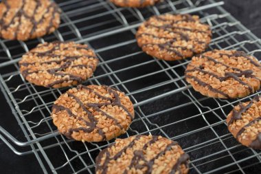 Siyah arka planda taze ev yapımı susamlı kurabiyelerin yakın plan fotoğrafı. Yüksek kalite fotoğraf