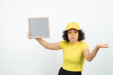 Beyaz arka planda pankartla poz veren genç kadın. 