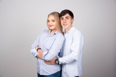 Gri arka planda kameraya bakan mutlu çiftin portresi. Yüksek kalite fotoğraf