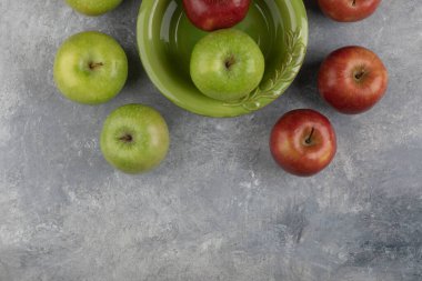 Yeşil kase mermer yüzeyde kırmızı ve yeşil elmalar. Yüksek kalite fotoğraf