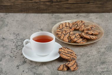 Susamlı kurabiyeler ve mermer yüzeyde bir fincan çay. Yüksek kalite fotoğraf