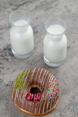 Çikolatalı çörek ve taş yüzeyde taze sütle süslenmiş. Yüksek kalite fotoğraf