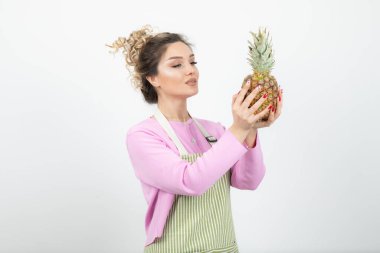 Elinde olgun ananas tutan önlüklü güzel bir kadının portresi. Yüksek kalite fotoğraf