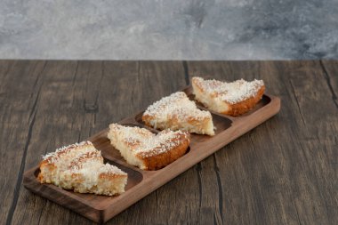 Tahta masa üzerinde hindistan cevizi parçacıkları serpiştirilmiş ahşap pasta dilimleri. Yüksek kalite fotoğraf