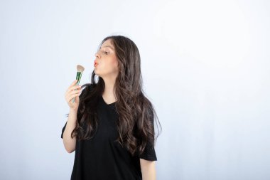 Beyaz arka planda duran allık fırçalı genç bir kızın portresi. Yüksek kalite fotoğraf