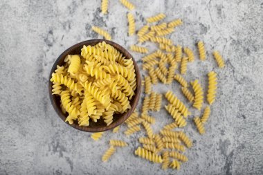 Taş yüzeyinde ahşap fusilli makarna kasesi. Yüksek kalite fotoğraf