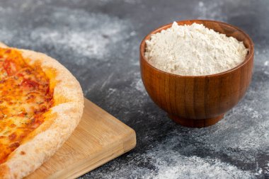 Tahta tahta bir pizza tahtası ve arka planda bir kase un. Yüksek kalite fotoğraf