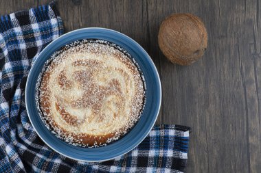 Tahta bir masaya taze hindistan cevizi konmuş bir tabak lezzetli turta. Yüksek kalite fotoğraf
