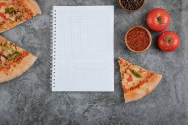 Lezzetli peynirli pizza dilimleri, baharatlar ve arka planda boş kağıt. Yüksek kalite fotoğraf