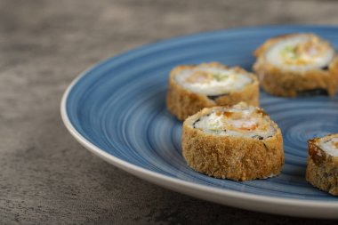 Mavi suşi ruloları bir taş masanın üzerine yerleştirilmiş. Yüksek kalite fotoğraf