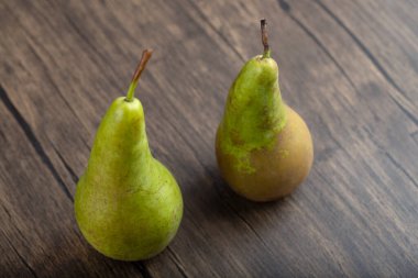 Ahşap zemin üzerinde iki olgun, lezzetli yeşil armut. Yüksek kalite fotoğraf