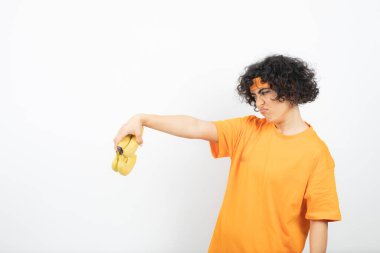 Beyaz arka planda izole edilmiş sarı saçlı ve silahlı genç Afrikalı Amerikalı kadın.