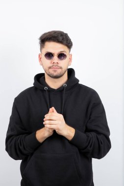 Gözlüklü genç yakışıklı adamın ayakta dikilip baktığı fotoğraf. Yüksek kalite fotoğraf