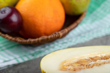 Arka planda kavun olan çeşitli taze meyvelerden oluşan bir sepet. Yüksek kalite fotoğraf