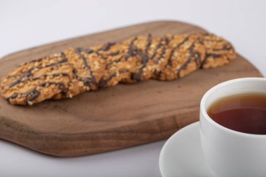 Beyaz masaya çok tahıllı kurabiyeler konmuş beyaz çay fincanı. Yüksek kalite fotoğraf