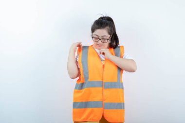 Gözlüklü güzel bayan mühendis üniformasını beyaz arka planda kontrol ediyor. Yüksek kalite fotoğraf