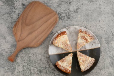 Tahtanın etrafına hindistan cevizi parçacıkları serpiştirilmiş lezzetli kek dilimleri. Yüksek kalite fotoğraf