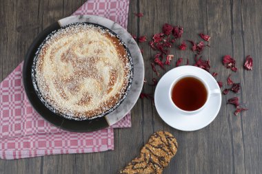 Tahta masaya bir fincan siyah çay ile bir tabak lezzetli turta. Yüksek kalite fotoğraf
